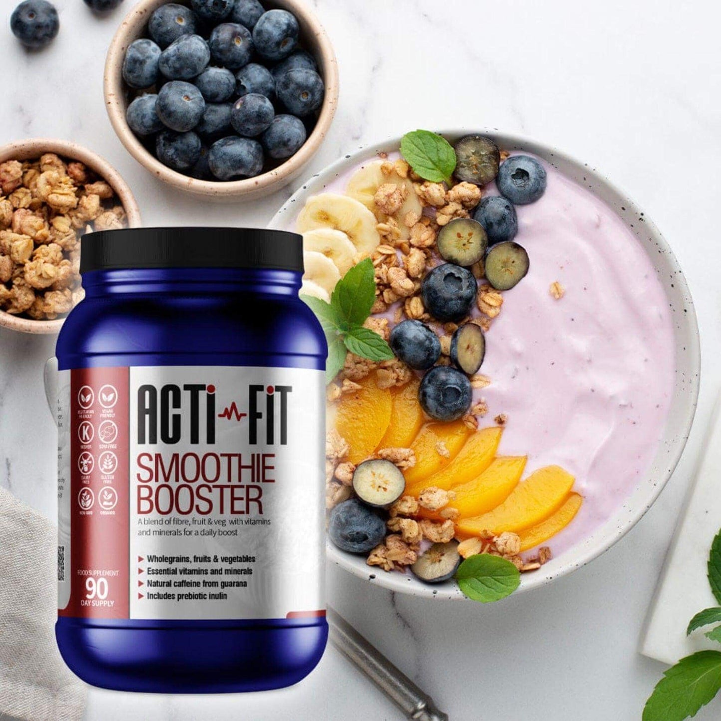 Acti-Fit Smoothie Booster tub beside a berry smoothie bowl topped with blueberries, banana, peach slices, granola and fresh mint.