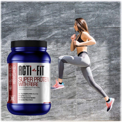 A woman stretching in a jump against a grey tiled background with a tub of Super Protein with Fibre in the foreground