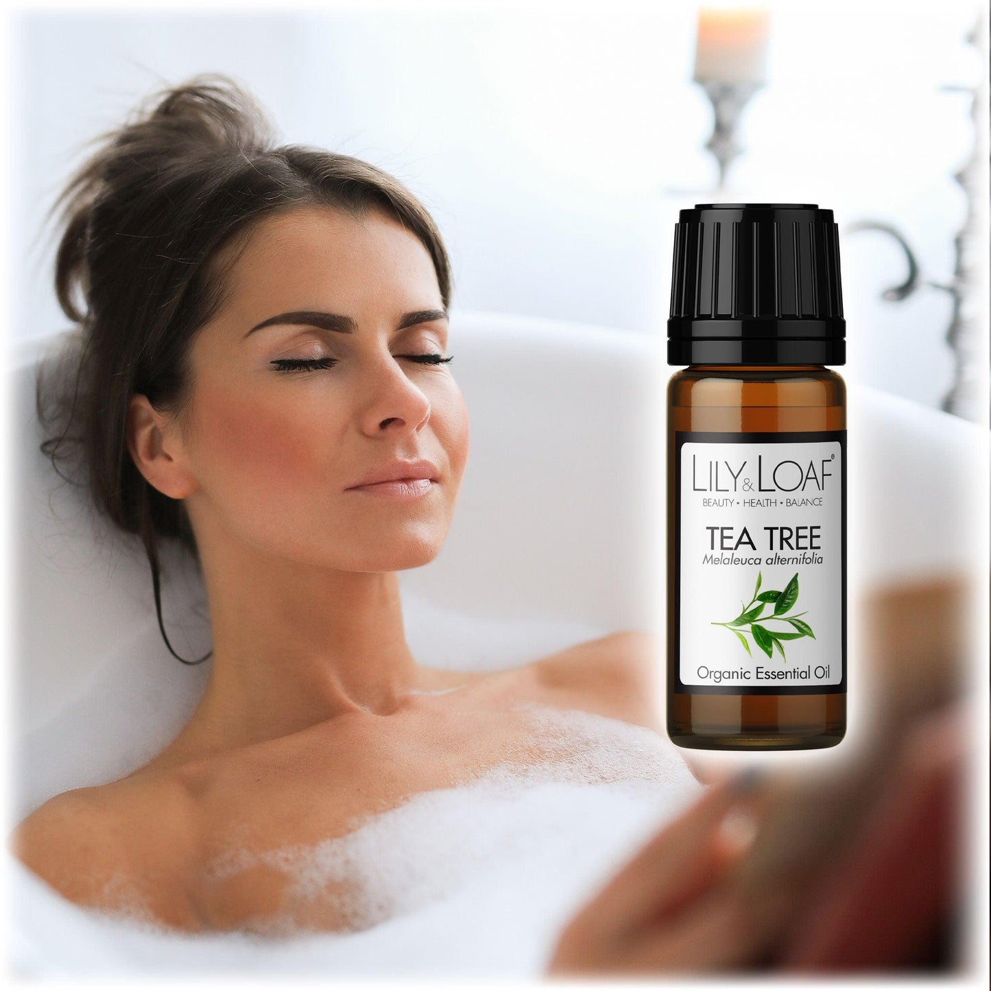 Woman relaxing in a bubble bath with eyes closed, alongside Lily & Loaf Tea Tree Organic Essential Oil bottle. Promotes antibacterial and cleansing benefits.