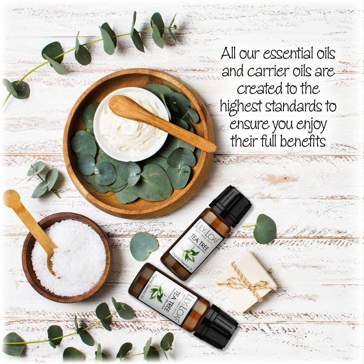 Tea Tree Organic Essential Oil surrounded by bath salts, cream and eucalyptus leaves depicting the high standards of creation