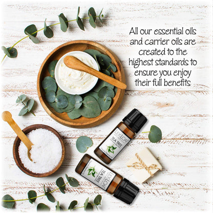 Tea Tree Organic Essential Oil surrounded by bath salts, cream and eucalyptus leaves depicting the high standards of creation